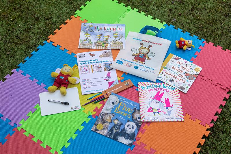 Contents of the Bookbug P1 Family Bag 2023 laid out on a colourful background